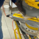 A sliding compound miter saw being used to make a cut.